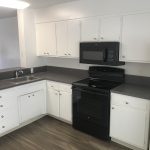 College Street Apartments kitchen with white cupboards and dark gray counters