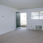 Sherwood & Forest Arms Apartments living room area with wall AC and front door to second floor entrance