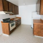Viking Apartments kitchen with dark wooden cabinets, orange counters and light tile floors