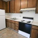 Viking Apartments kitchen with dark cabinets, white counters and white appliances