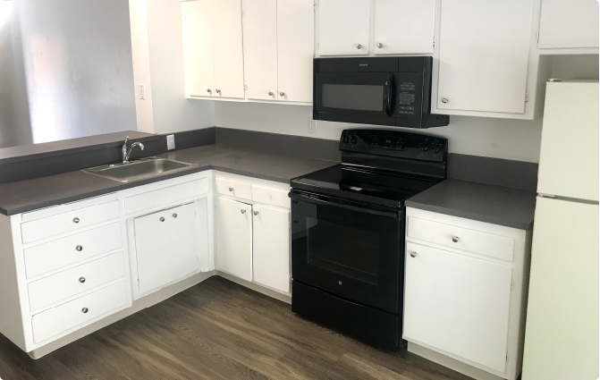 College Street Apartments kitchen with white cabinets and dark gray counters